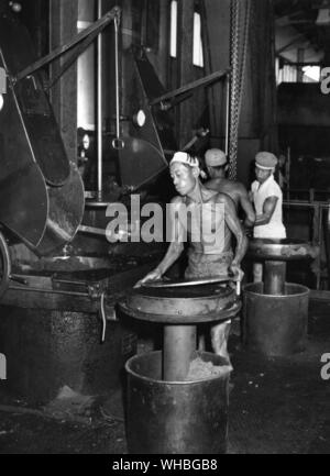 Oil palm fruit is loaded into presses and the oil collected in large tanks underneath , at this factory in North Sumatra , Indonesia Stock Photo