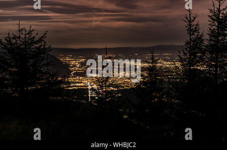 Evening top view of the city lights,French Annemasse, Swiss Geneva,dark sky background, photo with long exposure.Department of Haute-Savoie in France. Stock Photo