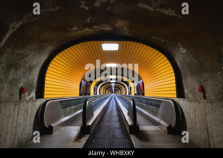 Pedestrian subway, illuminated tunnel, with two moving walkways. Stock Photo