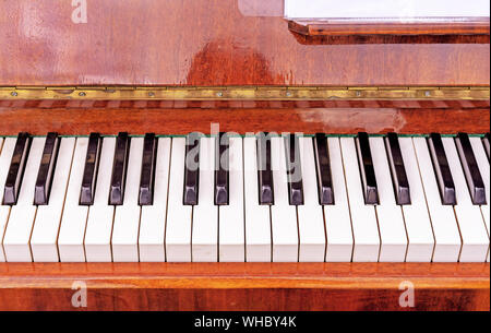 Keyboard on a brown piano. Black and white keys on the keyboard of the old piano. Stock Photo