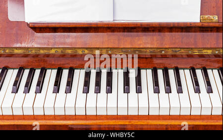 Keyboard on a brown piano. Black and white keys on the keyboard of the old piano. Stock Photo