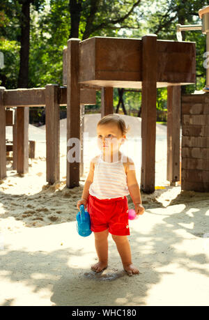 Cute kid with watering can in a playground Stock Photo
