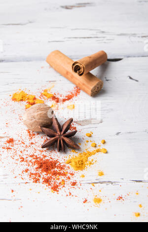 Beautiful food spice background: set of star anise, curcuma, cinnamon stick, nutmeg on white wooden background. Spices, ingredients for preparation mu Stock Photo