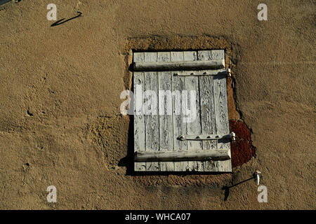 Old, wooden French shutter on rusty hinges. Stock Photo