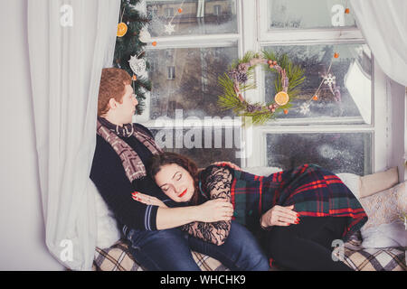 Christmas couple in a rural wooden house. Happy couple hugging. New Year & Christmas love story, studio photo shoot Stock Photo