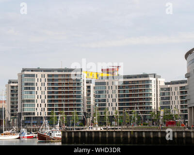 The giant Harland and Wolff Shipyard cranes tower over nearby buildings, Titanic Quarter, Belfast, Northern Ireland, UK Stock Photo
