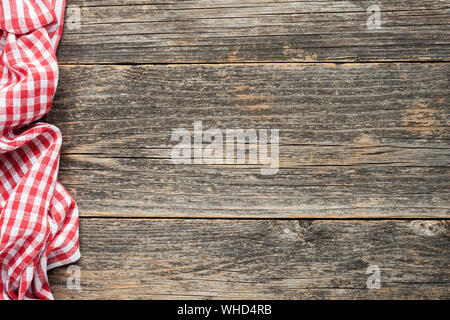 Red checkered picnic textile on rustic wooden planks background. Top view copy space. Cooking, food menu background Stock Photo