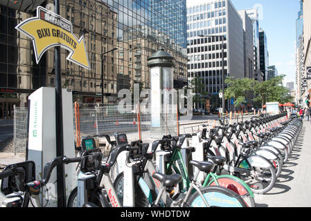 Montreal, Canada - August 24, 2019: Bixi bikes stand on de Maisonneuve boulevard, downtown. Bixi bikes are free to use every Sunday in order to boost Stock Photo