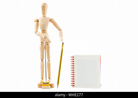 Wooden toy figure with pencil and notebook on white background Stock Photo