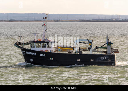 Fishing boat Indianna heading out to sea to fish late afternoon for the night out of Leigh on Sea passing Southend on the Thames Estuary. Industry Stock Photo