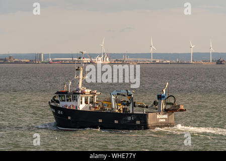 Fishing boat Indianna heading out to sea to fish late afternoon for the night out of Leigh on Sea passing Southend on the Thames Estuary. River Medway Stock Photo
