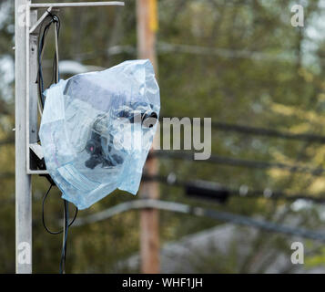 A fully automated camera to time track and field athletes is covered in plastic to protect it from the rain. Stock Photo