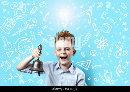 a boy in a light shirt smiles and rings a bell. Around it are various school icons on a blue background Stock Photo