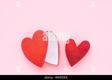 Tow red heart-shaped gift boxes on a pink background. Stock Photo