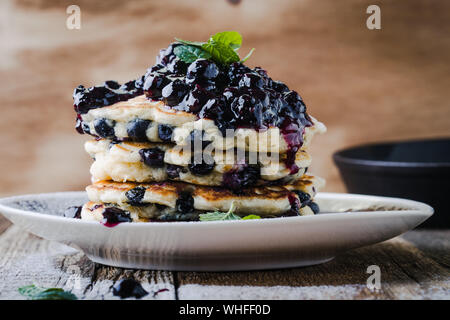 Homemade berry  pancakes, fresh summer dessert with blueberries on rustic wooden table,  close up, selective focus Stock Photo