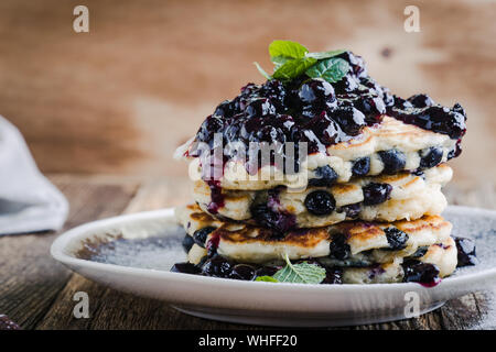 Homemade berry  pancakes, fresh summer dessert with blueberries on rustic wooden table,  close up, selective focus