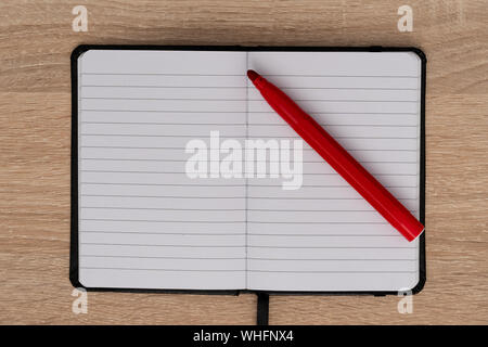 Red felt tip pen on open notebook Stock Photo