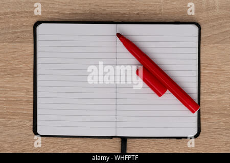 Open notebook with red pen on desk Stock Photo