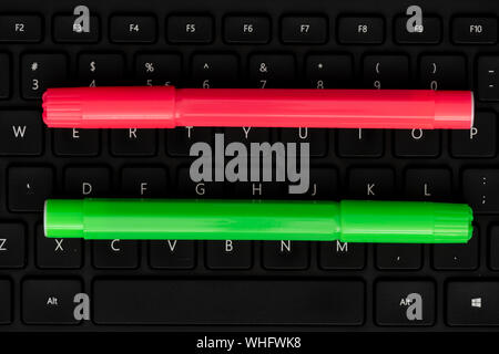 Pink pen and green marker on keyboard Stock Photo