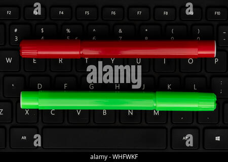 Green and pink markers on black keyboard Stock Photo