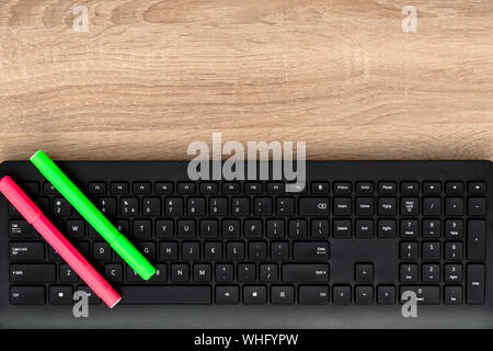 Green and peach markers on black keyboard Stock Photo