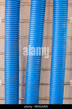 Corrugated blue plastic conduits with clips against a wall Stock Photo ...