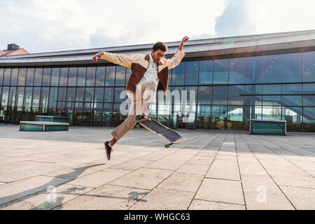 African american guy doing ollie with skateboard Stock Photo