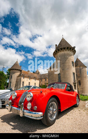 Beaune, France - Jun 12, 2010: Red classic Jaguar XK 140 sports car in front of the Savigny castle. Stock Photo