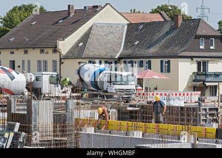 Construction workers collaborating in the installation of cement formwork frames Stock Photo
