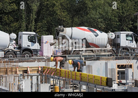 Construction workers collaborating in the installation of cement formwork frames Stock Photo