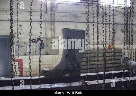 Rubber boots in mining dressing room and chains Stock Photo