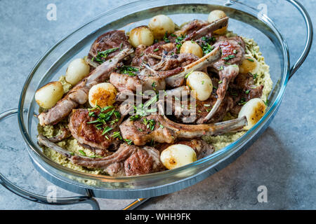 Lamb Chops with Shallots, Green Pea Hummus and Fresh Thyme Leaves served in Big Glass Tray Plate. Organic Meat Food. Stock Photo