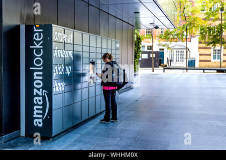Person picking up parcel from an self-service Amazon Locker, London, UK Stock Photo