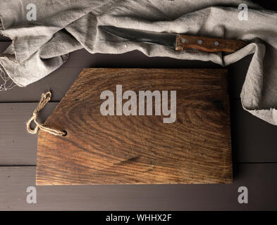 empty old wooden kitchen chopping boards and a gray towel on a brown table, view from the top Stock Photo