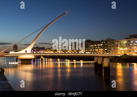 Illuminated Samuel Beckett Bridge Over River Against Sky