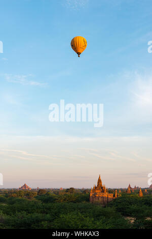 BAGAN, MYANMAR - 06 DECEMBER, 2018: Vertical picture of hot air balloon over the old temples during sunny day in Bagan, Myanmar Stock Photo