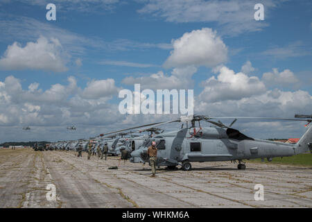 Sailors secure U.S. Navy MH-60R Sea Hawk helicopters after arriving at Maxwell Air Force Base, Alabama, from Naval Air Station Jacksonville and Naval Station Mayport, Florida, Sept. 1, 2019. The helicopters evacuated from the Jacksonville area in advance of Hurricane Dorian. In addition to the helicopters, Maxwell AFB is serving as an Incident Support Base for Federal Emergency Management Agency and Defense Logistics Agency personnel and equipment. (U.S. Air Force photo by Billy Birchfield) Stock Photo