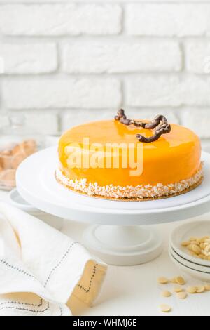 Vertical selective closeup shot of a yellow cake with coconut seeds on a cake stand Stock Photo
