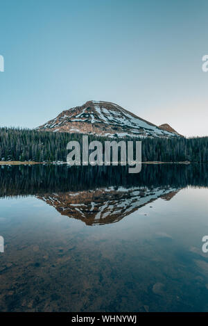Snowy mountains reflecting in Mirror Lake, in the Uinta Mountains, Utah Stock Photo