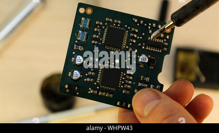 Workshop on repair of household appliances, electronics and processors. soldering Board soldering iron, re-soldering chips, replacing transistors, thy Stock Photo