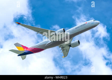 Passenger airplane Airbus A350 of Asiana Airlines flying through clouds sky take off from Tan Son Nhat International Airport, Ho Chi Minh City, Vietna Stock Photo