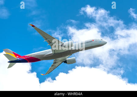 Passenger airplane Airbus A350 of Asiana Airlines flying through clouds sky take off from Tan Son Nhat International Airport, Ho Chi Minh City, Vietna Stock Photo