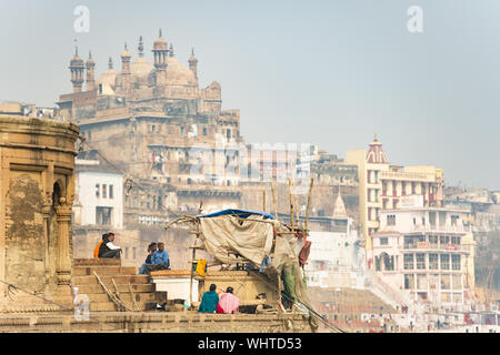 Some Hindu people are relaxing on a Ghat in Varanasi. Stock Photo