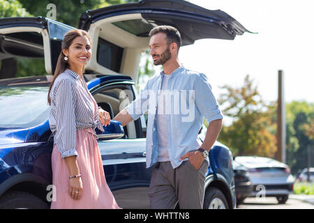 Stylish loving couple standing near their nice luxury car Stock Photo