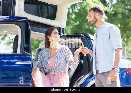 Wife seeing her handsome husband meeting her near car Stock Photo