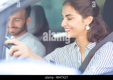 Wife wearing stylish earrings driving car sitting near husband Stock Photo