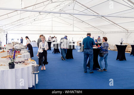 Russia Kemerovo 2019-07-27 People at catering stand-up meal party, waiters, guests on banquet, table setting, wine glasses, snacks, alcohol, plates Stock Photo