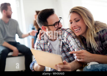 Young happy friends relaxing and looking at digital tablet Stock Photo