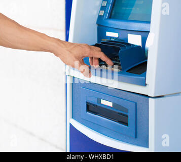 Blue ATM machine. Closesup of hand pushing buttons Stock Photo