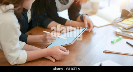 Close-up view of young start up team planing the upcoming project together with tablet in modern office room Stock Photo